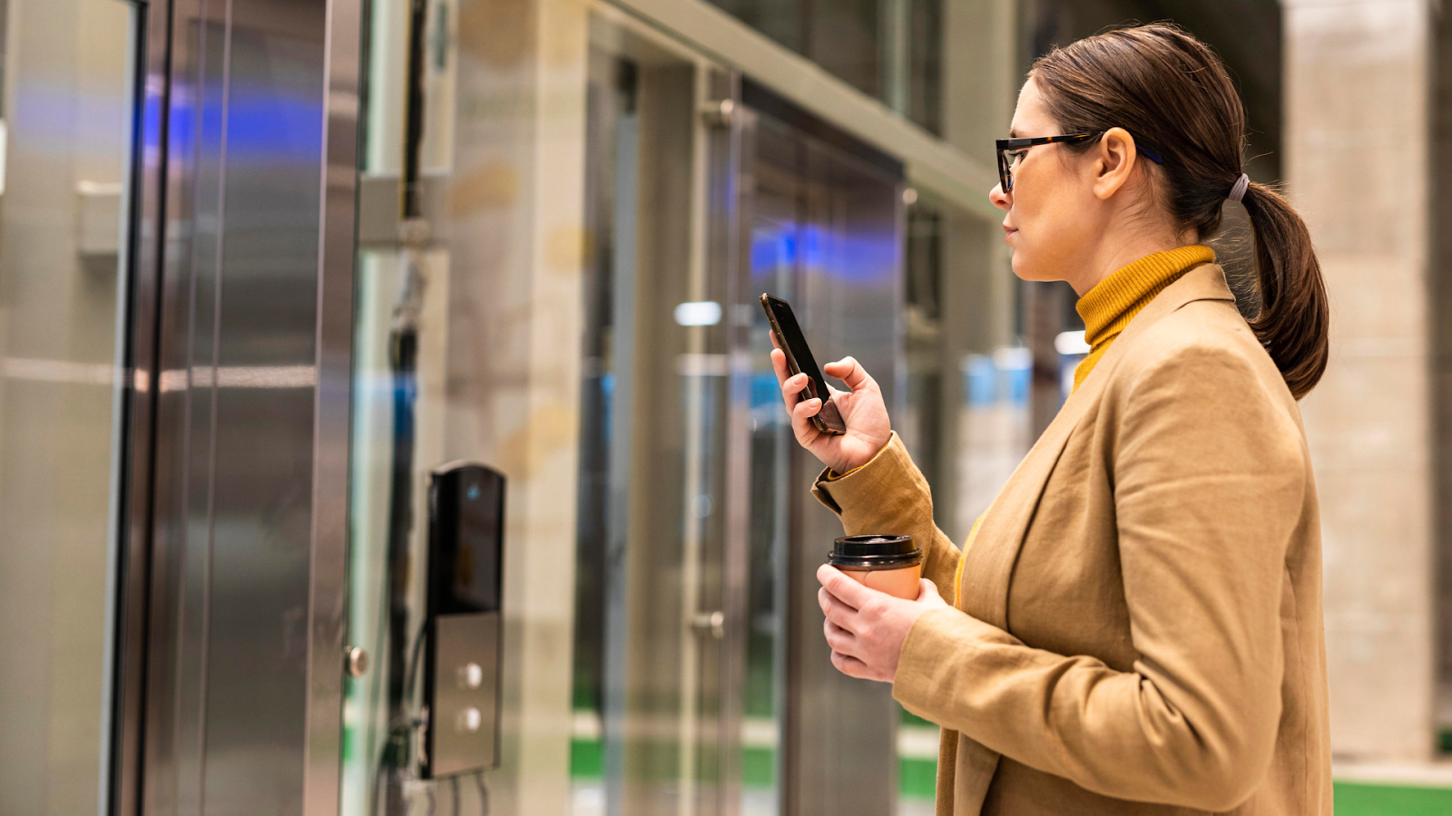 Executiva utilizando sistema de autenticação facial para controle de acesso em ambiente corporativo, demonstrando aplicação prática da tecnologia em empresas.