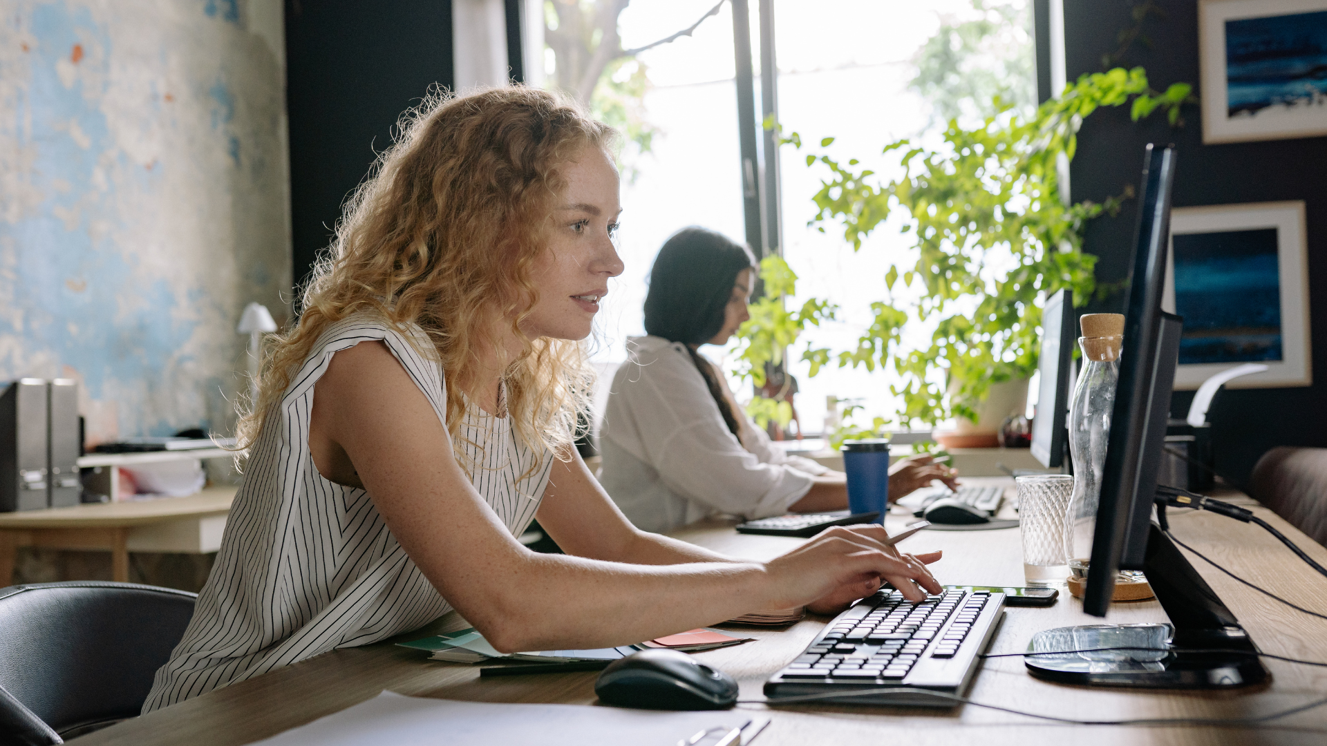 Profissionais trabalhando em computadores em um escritório moderno, com foco em processamento local de dados e conectividade inteligente, ilustrando o uso de Edge Computing em ambientes corporativos para maior desempenho e agilidade.
