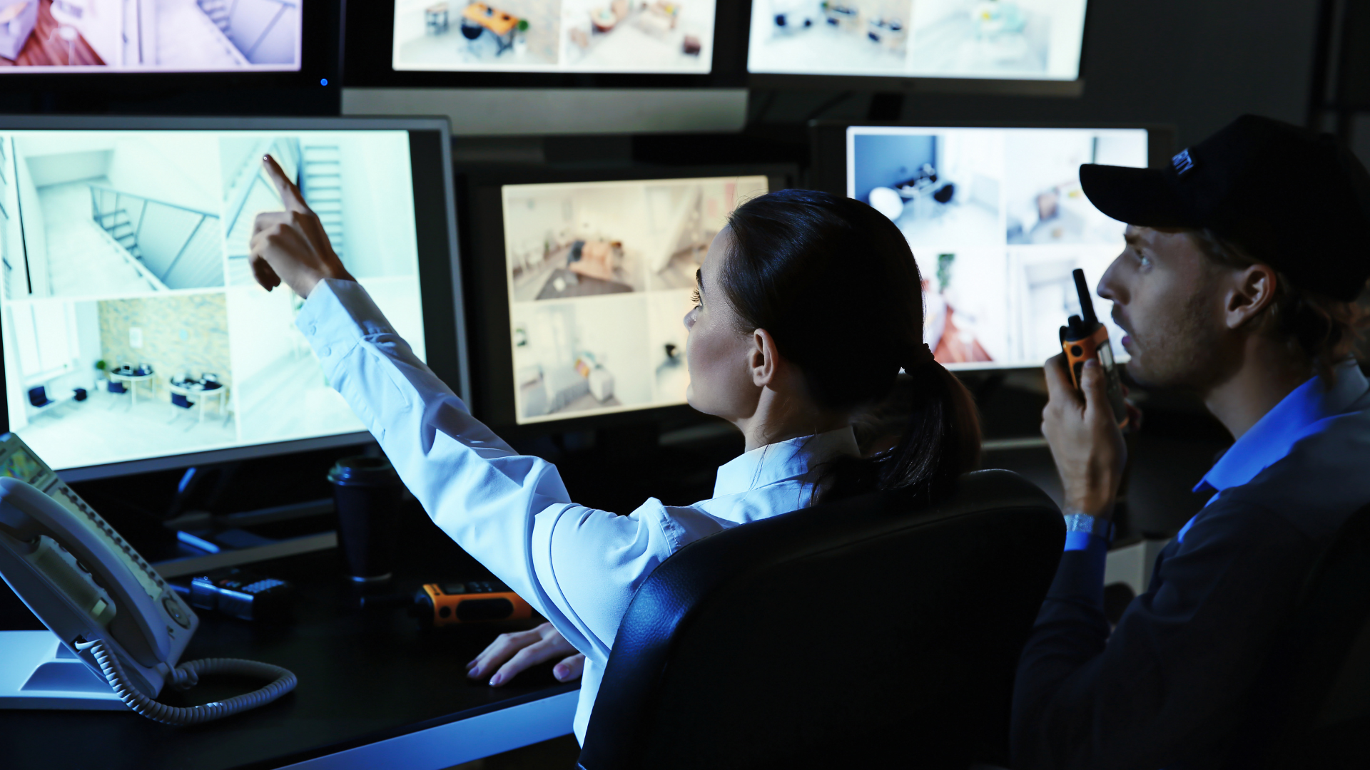 Operadores de segurança monitoram diversas câmeras em uma central de vigilância, analisando imagens em tempo real para identificação de eventos e resposta rápida, representando um sistema de CFTV Inteligente voltado ao monitoramento, análise de vídeo e proteção de ambientes.